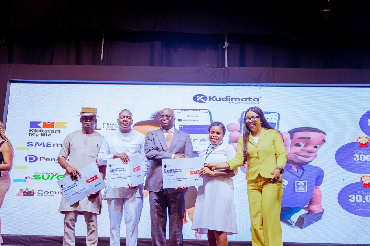 Chief of Staff to Delta Governor, Hon Johnson Erijo (middle) joined by the founder/ GMD, Kudimata Nigeria Limited, Kathleen Erhimu (right) as he makes presentation of a cheque for empowerment on behalf of Prudent Energy in collaboration with Kudimata to a beneficiary ( 2nd right) at a Small Medium Enterprises 2024 Conference in Asaba on Friday. With them are stakeholders at the event.