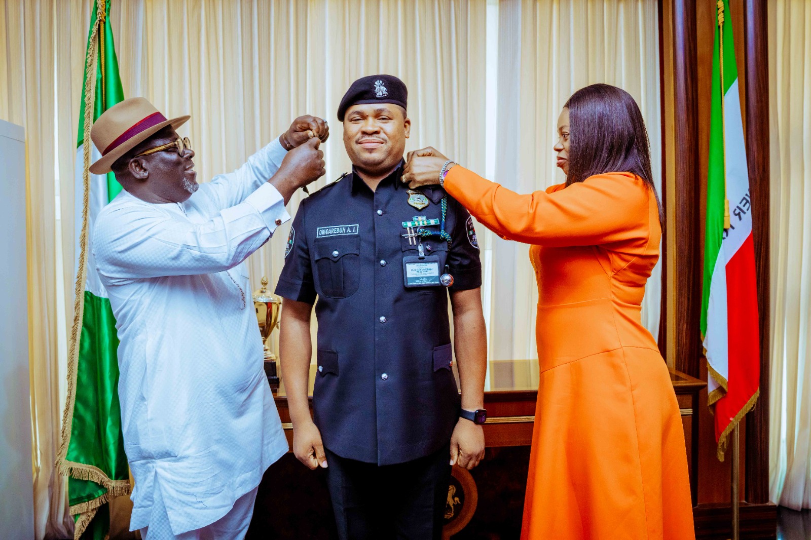 Delta State Governor, Rt Hon Sheriff Oborevwori (left), assisted by Mrs Victoria Omoarebun Iluobe, wife of the newly promoted CSO, Mr. Omoarebun Iluobe (right), decorating him (Mr. Omoarebun), with his new rank as Chief Superintendent of Police (CSP) in the Governor's office in Asaba on Friday, January 10, 2025